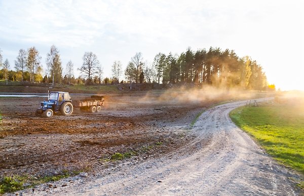 En traktor sprider gödsel på en åker